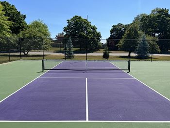 A tennis court with purple and green playing surface.